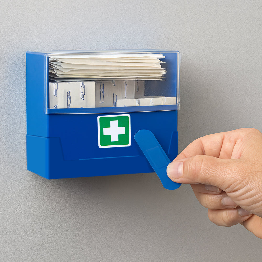 Blaue Pflasterbox an der Wand, Hand zieht Pflaster aus dem Ausgabefach