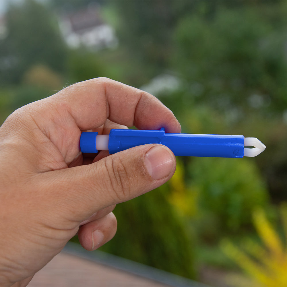 MC24® Zeckenzange in der Hand: blaues Kunststoffwerkzeug mit weißem Greifer