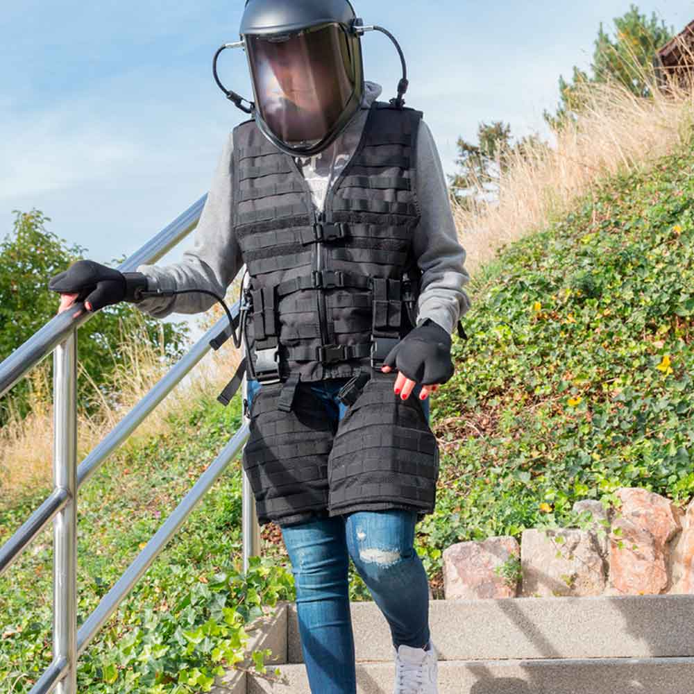 Alters-Simulator: schwarze Weste mit Tragesystem, Gesichtsvisier, Handschuhe und blaue Jeans