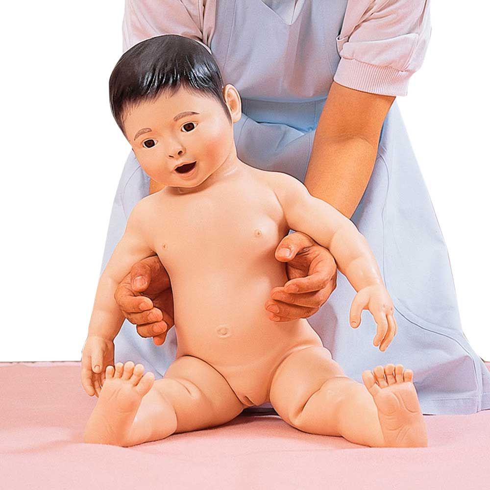 Weibliche Säuglings-Krankenpflegpuppe sitzend auf einer Unterlage mit dunklen Haaren