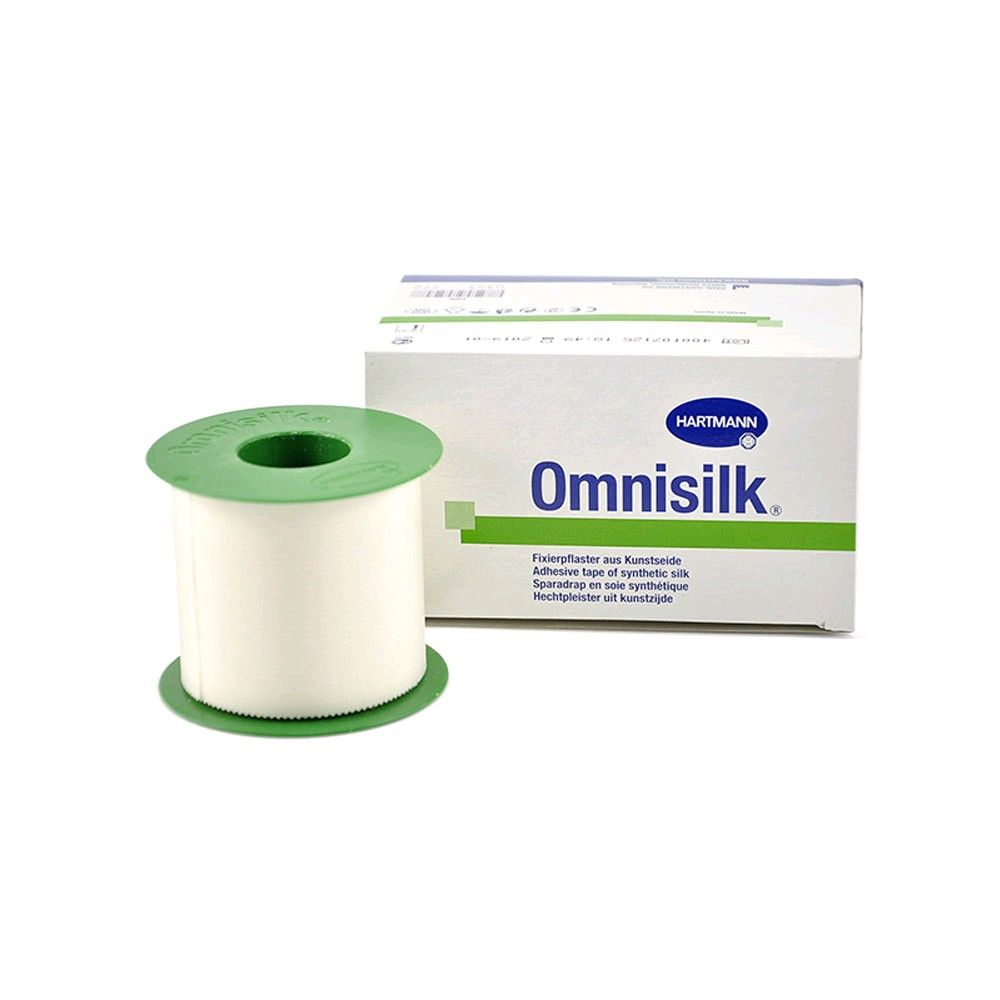 Fixierpflaster-Rolle neben Kartonverpackung mit Omnisilk-Aufdruck