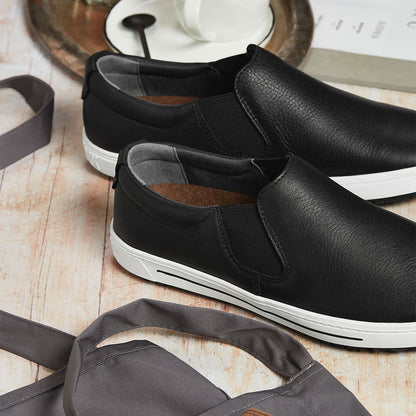 Zwei schwarze Lederschuhe mit seitlichem Gummizug und heller Profilsohle.